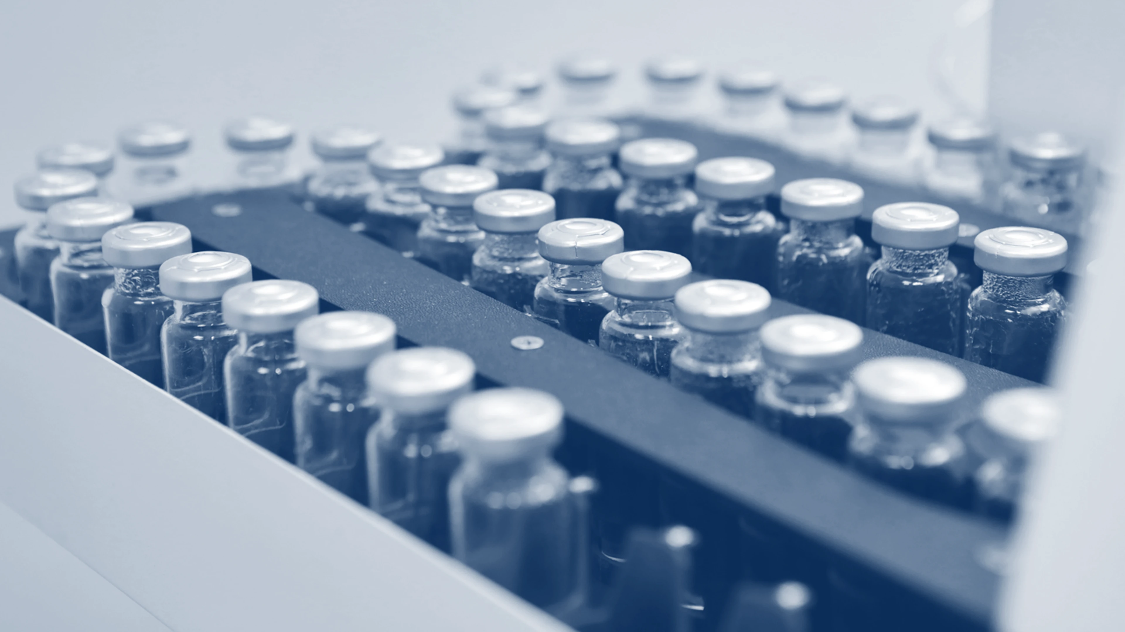 Lines of vaccines on a conveyor belt in a manufacturing laboratory